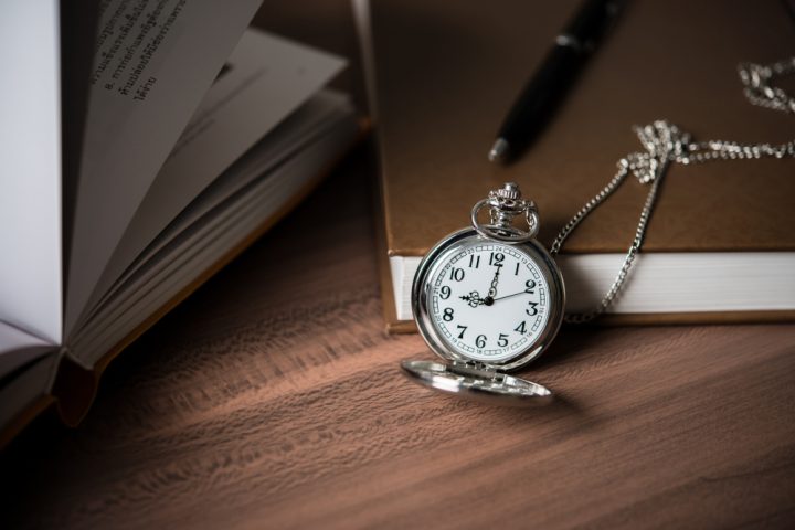 petite horloge posé sur un livre