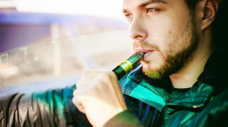 un homme vapotant une cigarette électronique